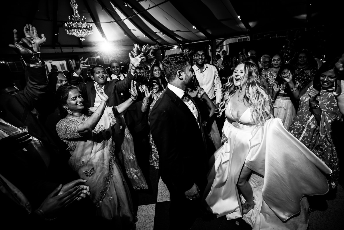 black and white image of the bride and groom dancing with all of their guests during their Ashcombe Mansion Wedding reception