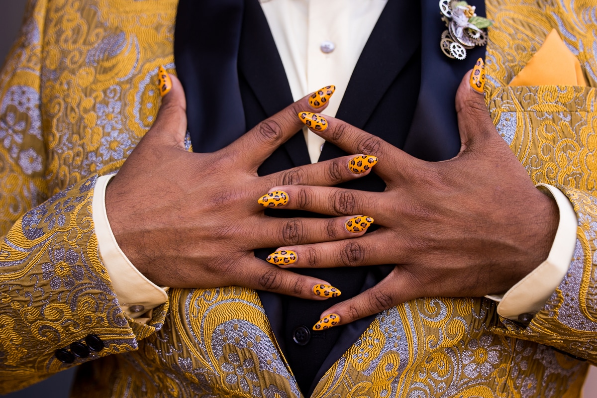 unique image of one of the wedding party's cheetah print yellow nails against their yellow and navy tux and shirt