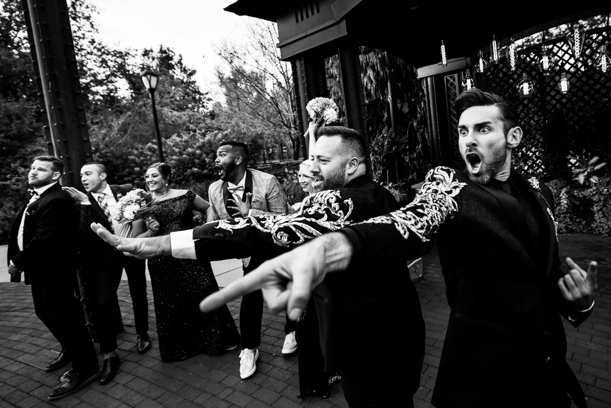 black and white image of the grooms and some of the wedding party acting during their wedding ceremony