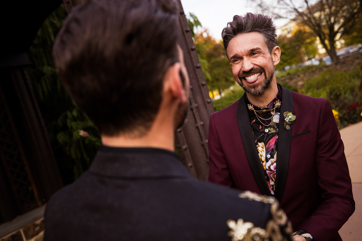image of the groom and someone in the wedding party smiling and sticking their tongue out during the wedding ceremony