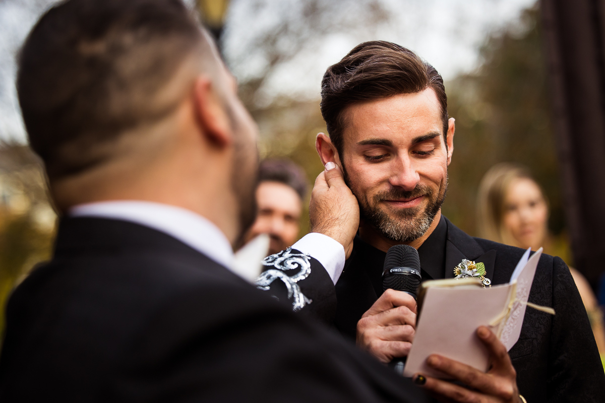 philadelphia wedding photographer, lisa rhinehart, captures image of the one groom rubbing the other grooms ear as he shares his wedding voews