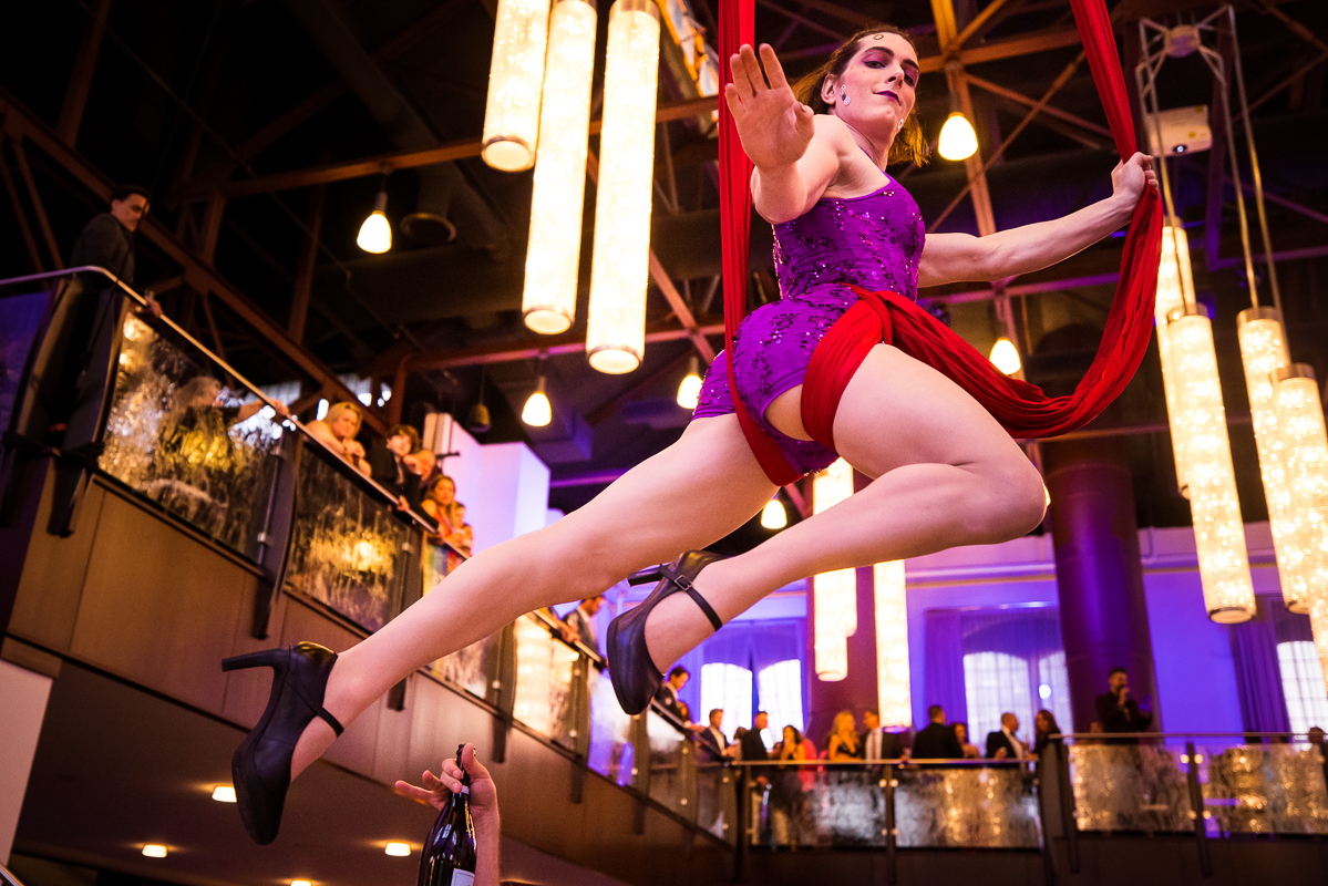 Philly photographer, Lisa Rhinehart, captures aerialists hanging from the ceiling and giving out drinks during cocktail hour 