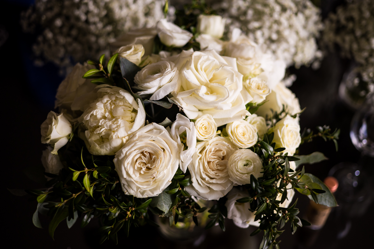 Image taken during the detail photos of the bridal bouquet which is filled with all white flowers and greenery mixed in for this wedding ceremony