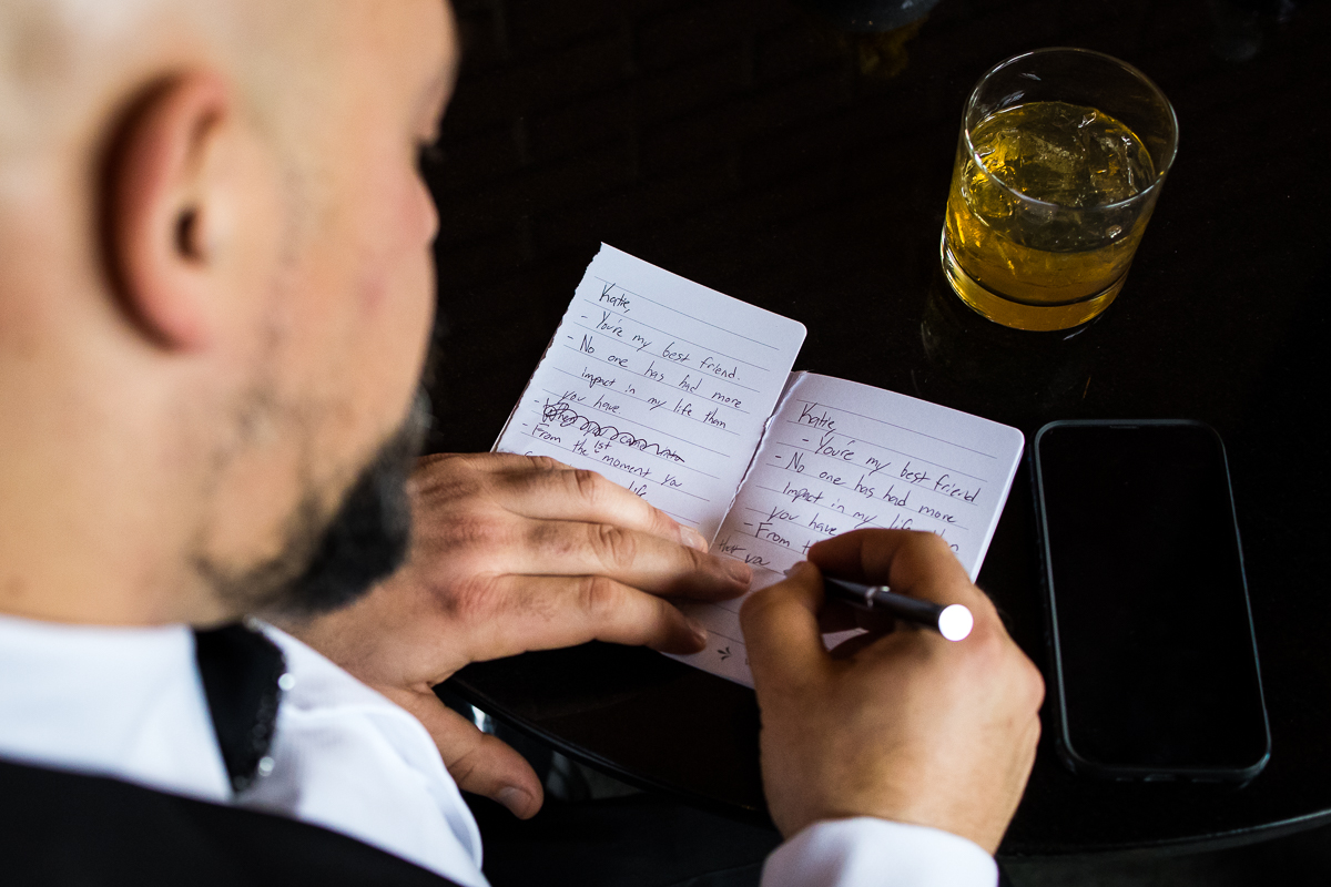 Creative, unique image of the groom hand writing his vows before his Ritz Carlton Georgetown Wedding 