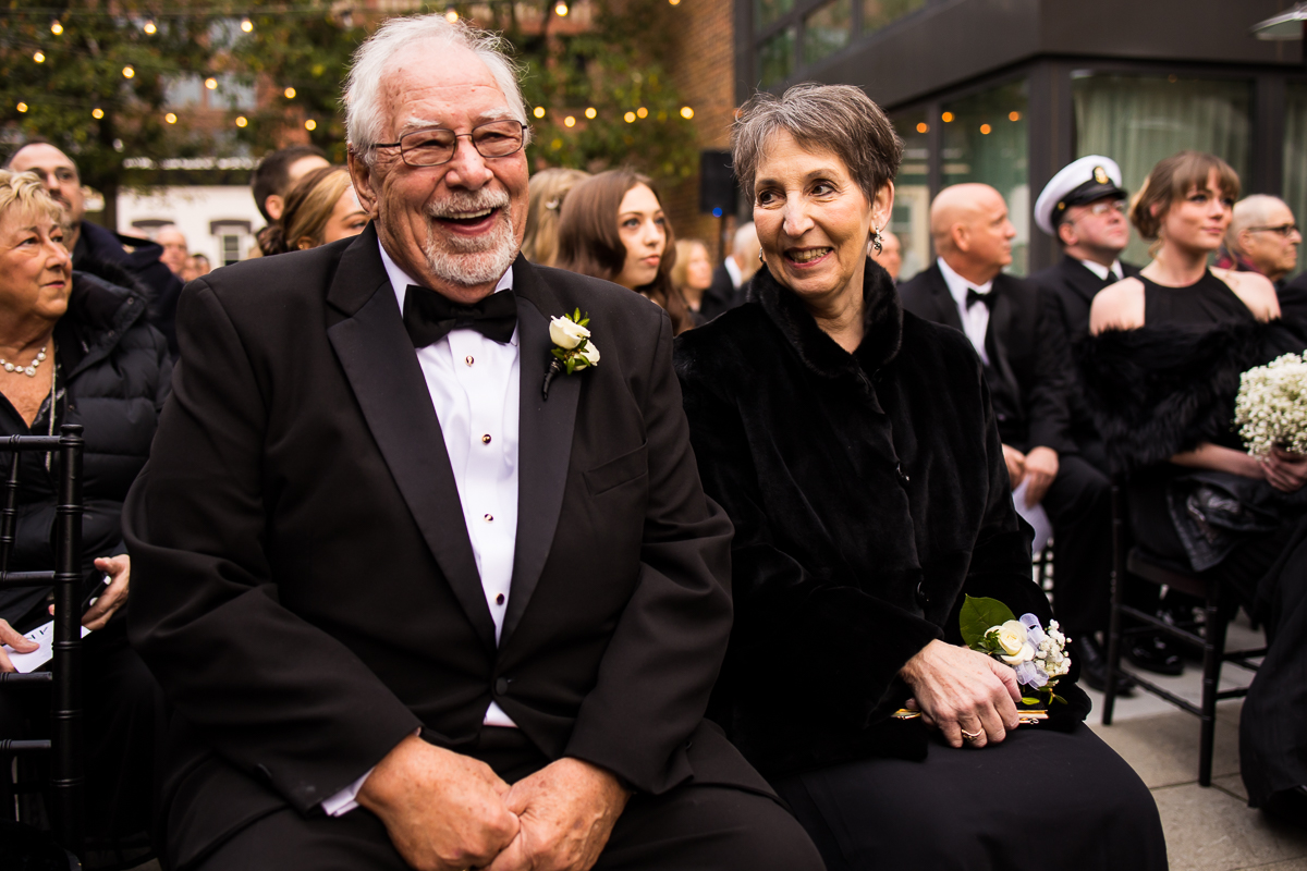 Ritz Carlton Georgetown Wedding photographers, rhinehart photography, captures the bride and grooms parents smiling as they sit and wait for the wedding ceremony to start 