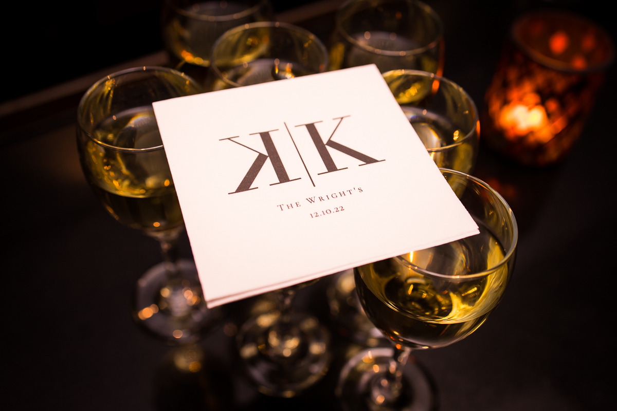Creative, unique image of the couple napkins with their initials sitting ontop of drink glasses before their wedding reception