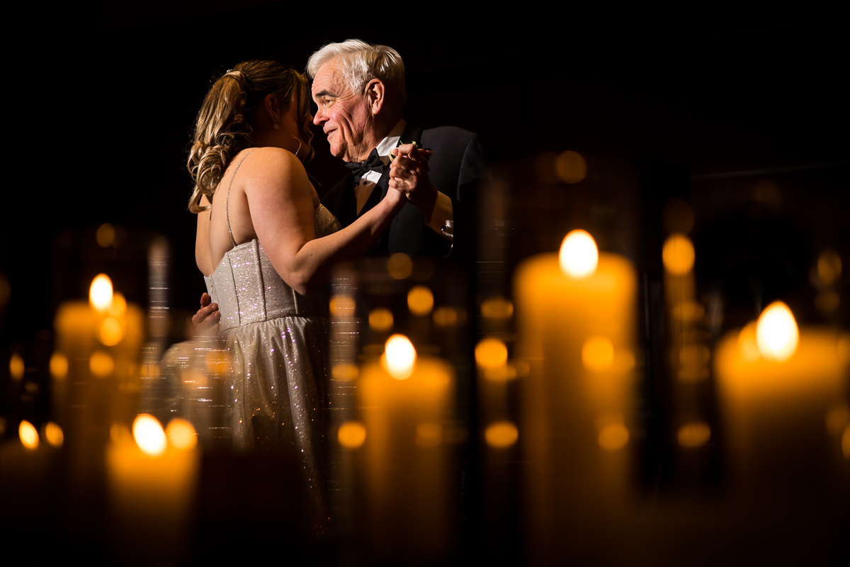 creative, unique image of the bride and her father sharing their first dance surrounded by relfections of the candles during this Ritz Carlton Georgetown Wedding reception 
