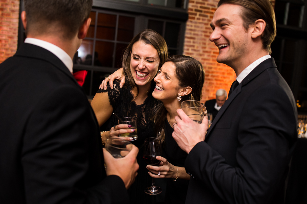 image of the wedding guests hugging, laughing, and smiling during this winter wedding reception 