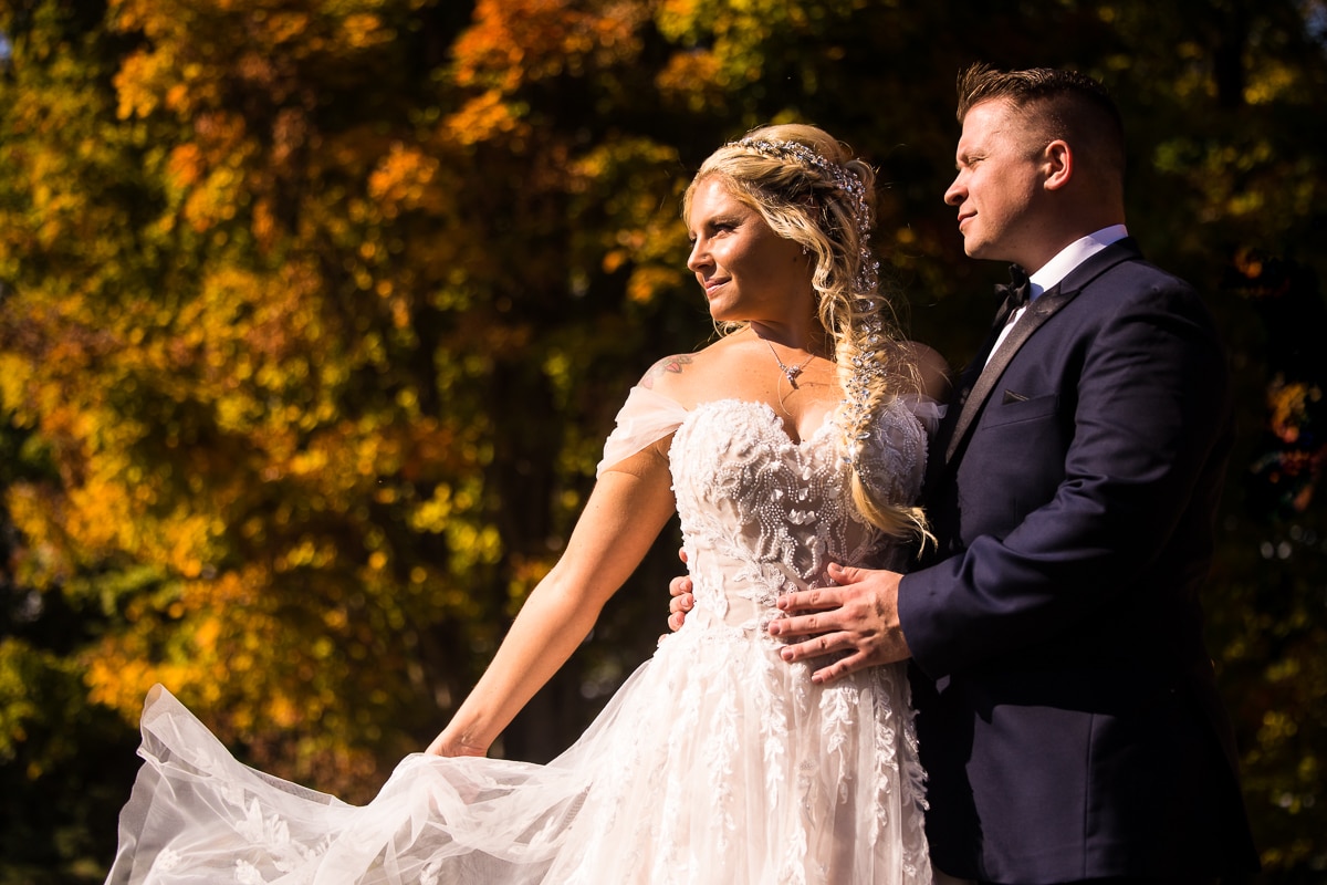 image of the bride looking away holding her dress and the groom looks off into the distance with her during their stroudsmoor wedding ceremony and reception