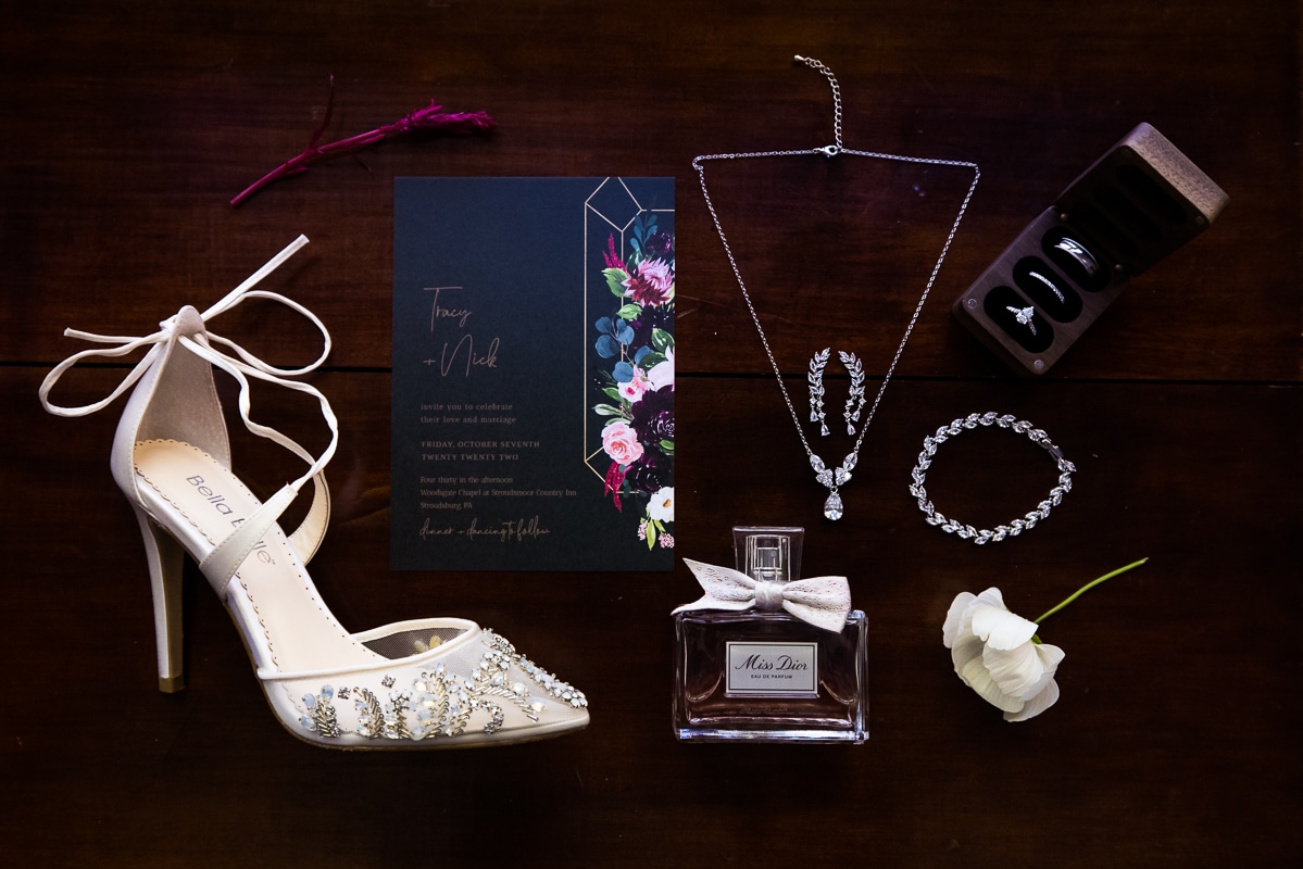 stroudsmoor photographer, lisa rhinehart, captures a unique image of the wedding details including shoes, jewelry, invitations, perfume and flowers before the wedding ceremony in the poconos