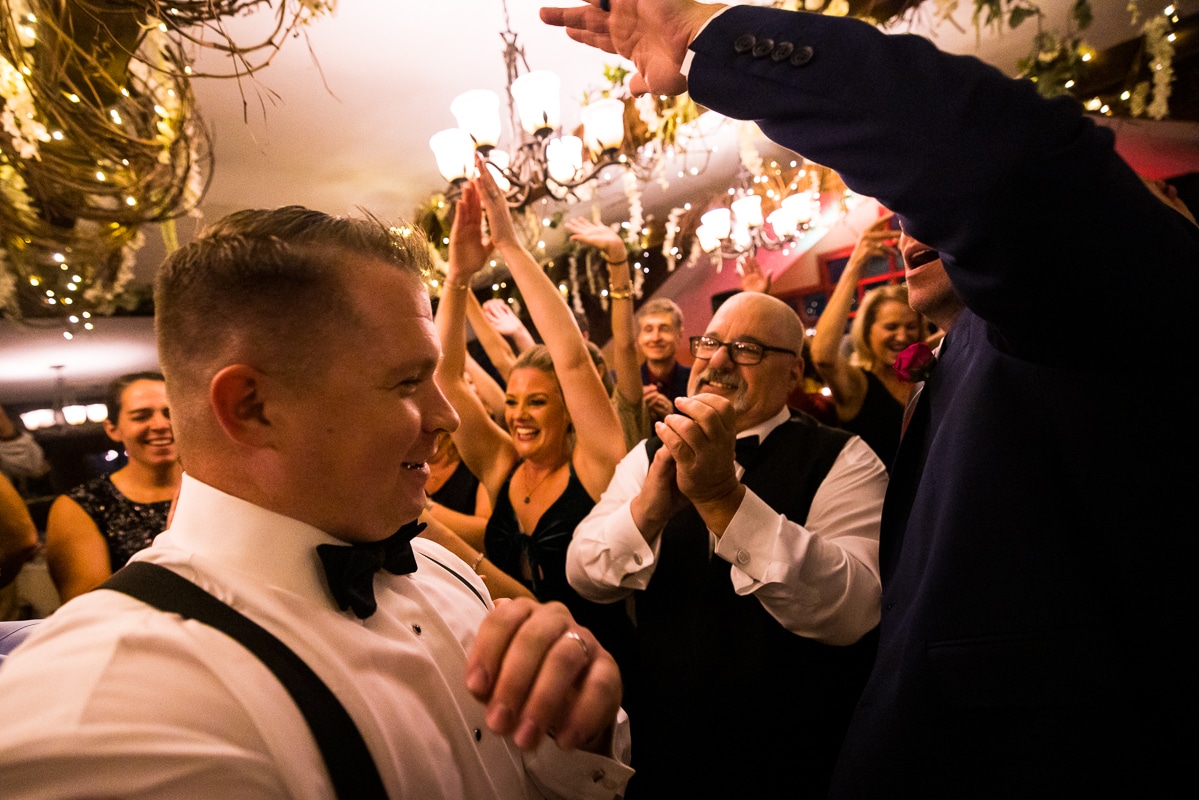 image of the groom and guests dancing together during this pocono wedding reception at the stroudsmoor 