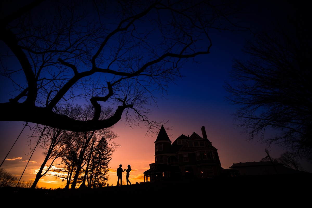 Central PA photographer, Lisa Rhinehart, captures this colorful and vibrant sunset with the couple and the mansion silhouetted during their Ashcombe Mansion Engagement session