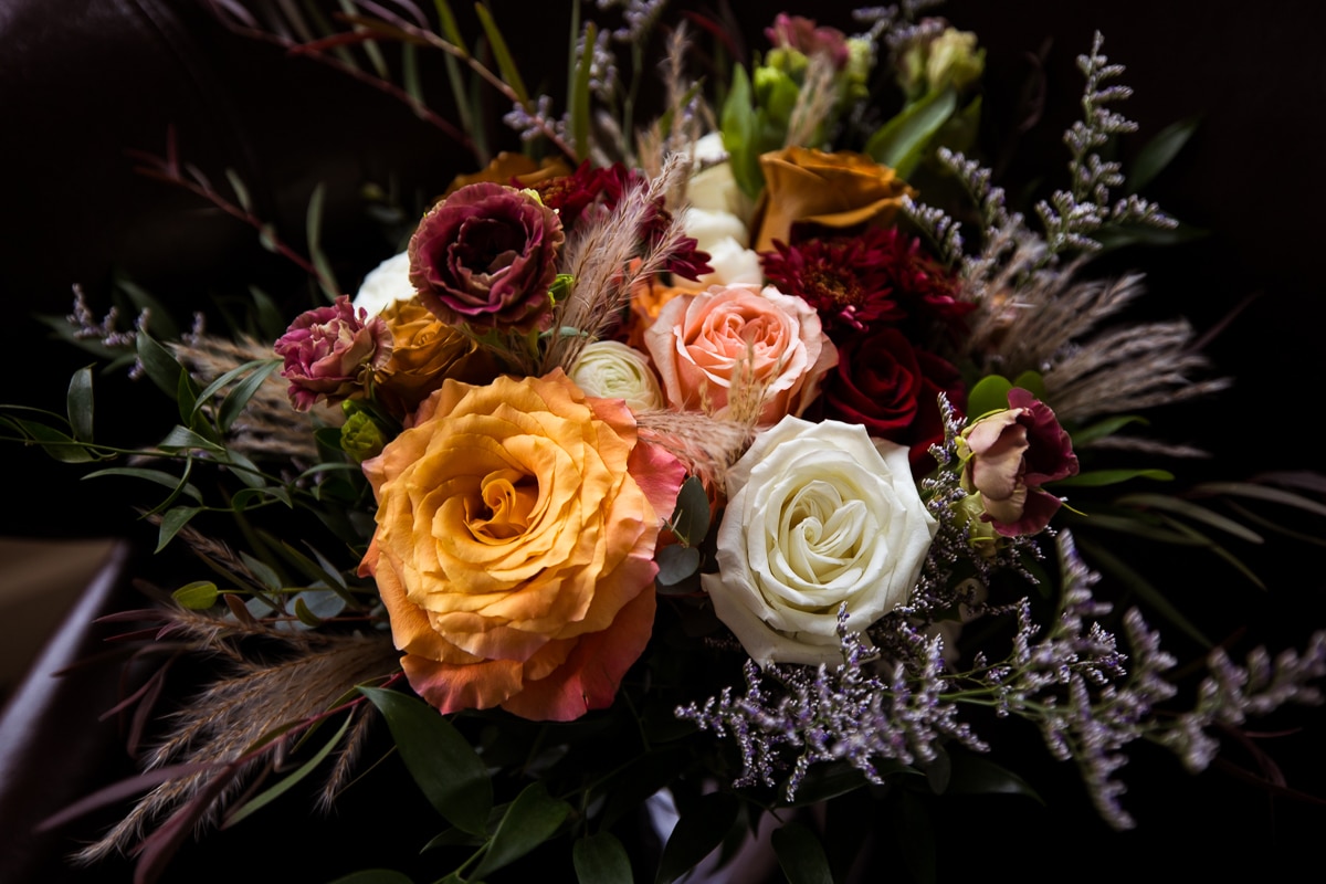 Image of the brides Colorful, fall bouquet filled with a variety of flowers in varying colors of orange, pink, red, white, purple and green 