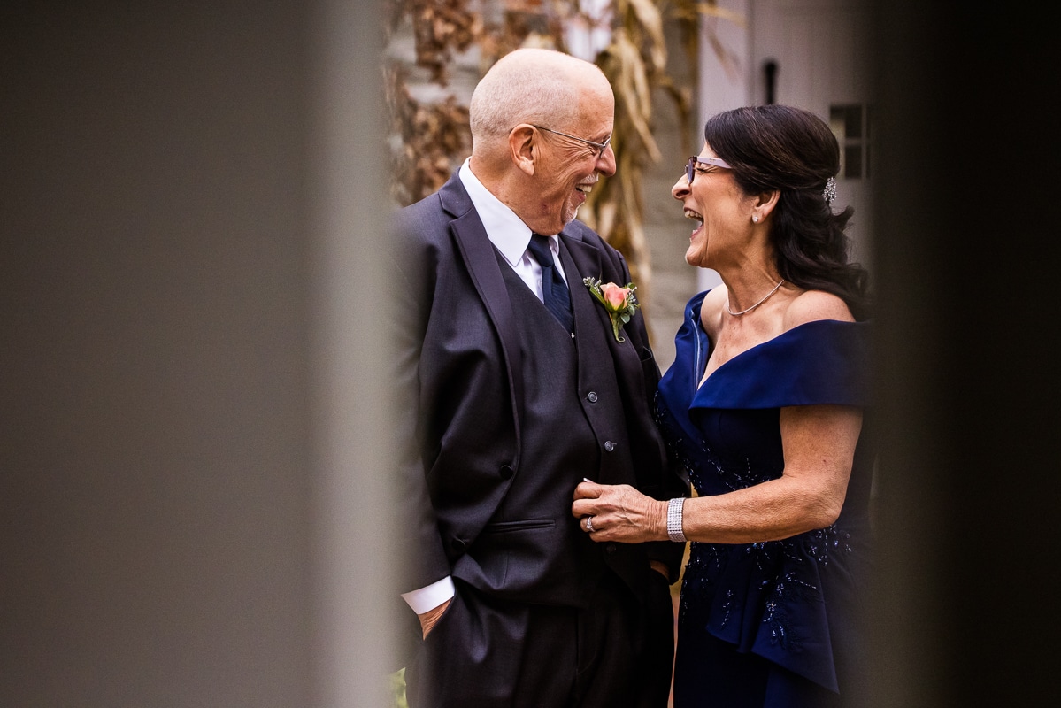 Ryland Inn Wedding Photographer, lisa rhinehart, captures this unique candid image of the brides mom and dad smiling at one another before the wedding ceremony 