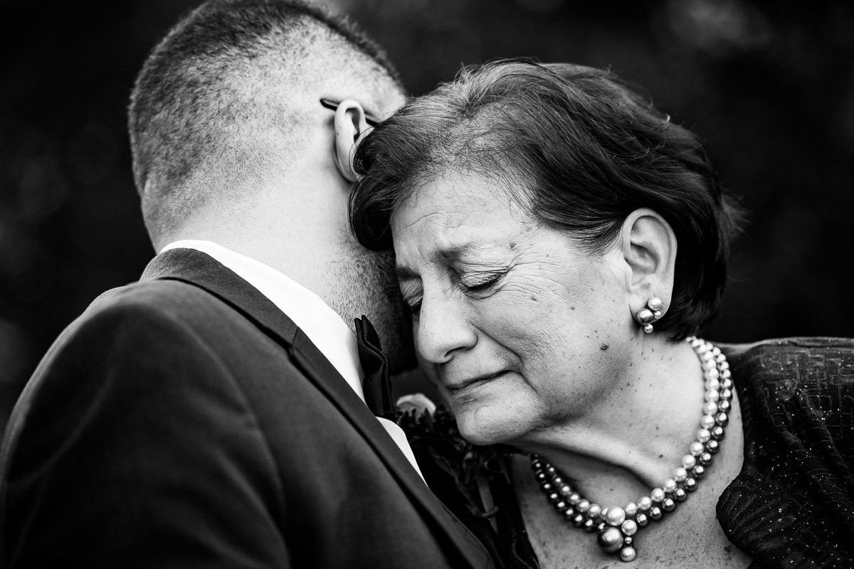 Ryland Inn Wedding Photographer, lisa rhinehart, captures this black and white authentic moment between the groom and his mom as they lean in to hug one another and the mom is starting to cry 