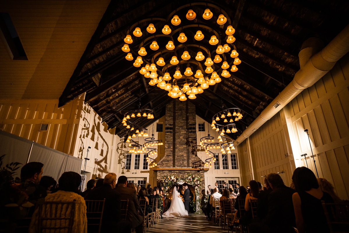 lisa rhinehart, captures the unique lighting of the ryland inn and all of the decor as. the bride and groom continue their wedding ceremony 