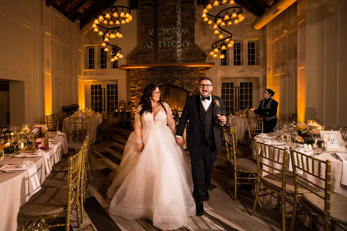 image of the bride and groom walking through their reception venue for the first time all decorated with giant smiles on their faces 