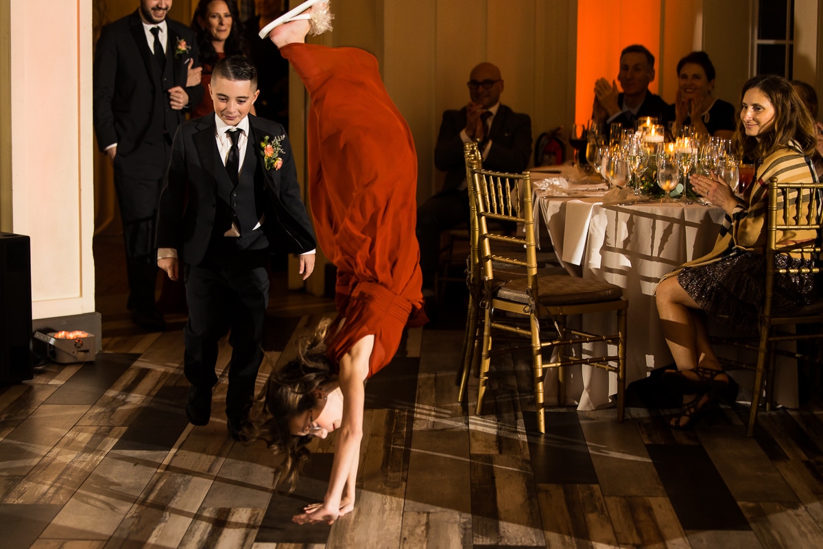 wedding photographer, lisa rhinehart, captures the jr bridesmaid doing a cartwheel in for her entrance to the wedding reception