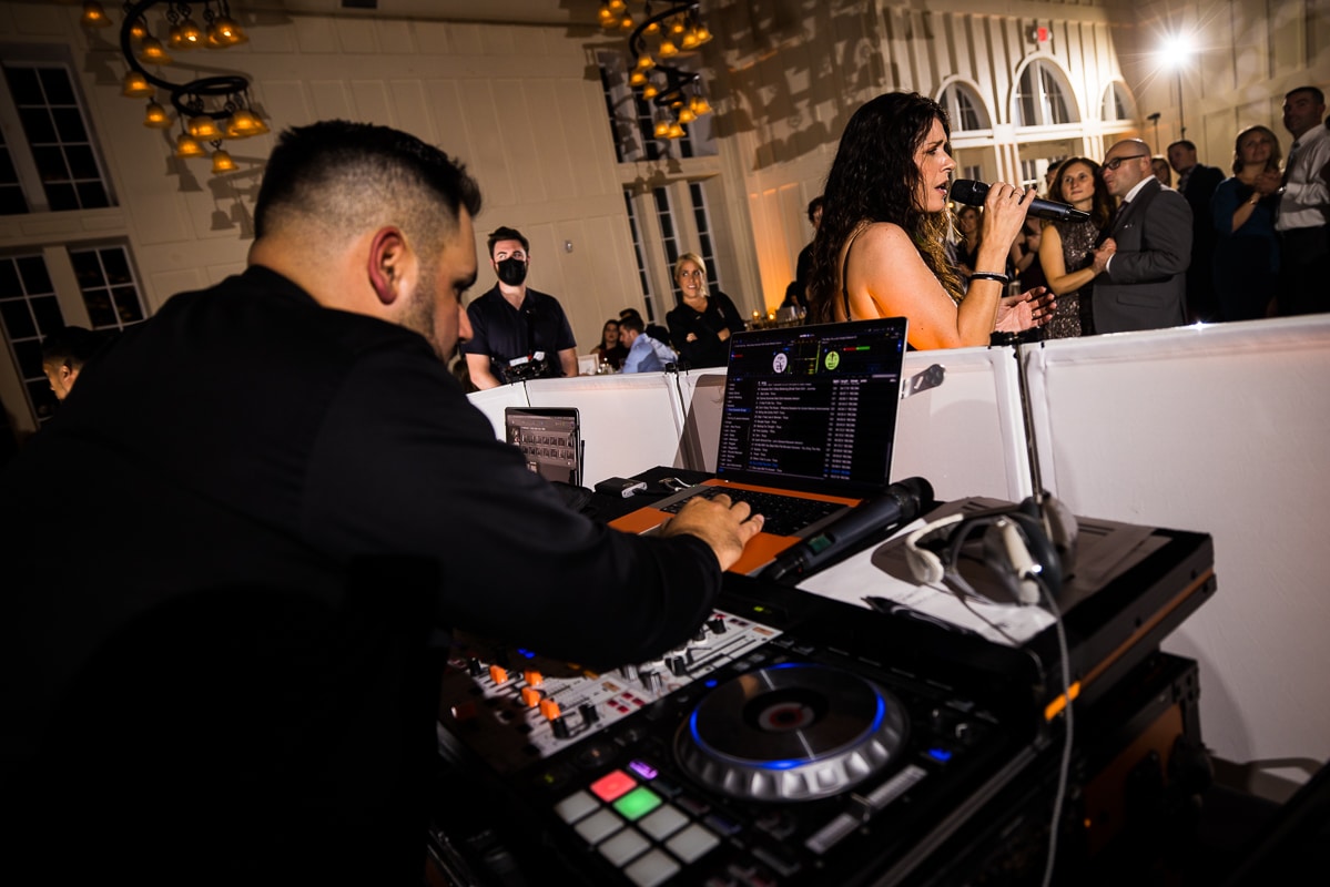 Ryland Inn Wedding Photographer, lisa rhinehart, captures the DJ mixing music and getting the party started as there is a live singer in front of him singing for the reception 