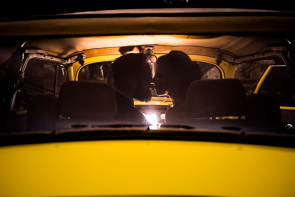 Gettysburg Hotel Wedding Photographer, lisa rhinehart, captures the couple inside of the yellow packard convertible as they lean in for a kiss at the end of their wedding night