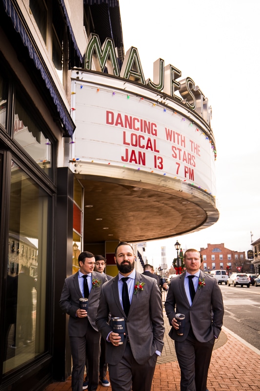 Gettysburg wedding photographer, lisa rhinehart, captures the groom and his groomsmen walking in downtown Gettysburg by the Majestic Theatre before their wedding ceremony at Mount St. marys