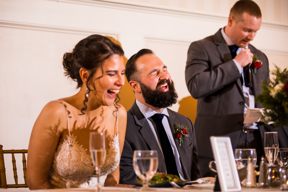 central pa wedding photographer, lisa rhinehart, captures the bride and groom laughing and smiling as their friends toast to their relationship 