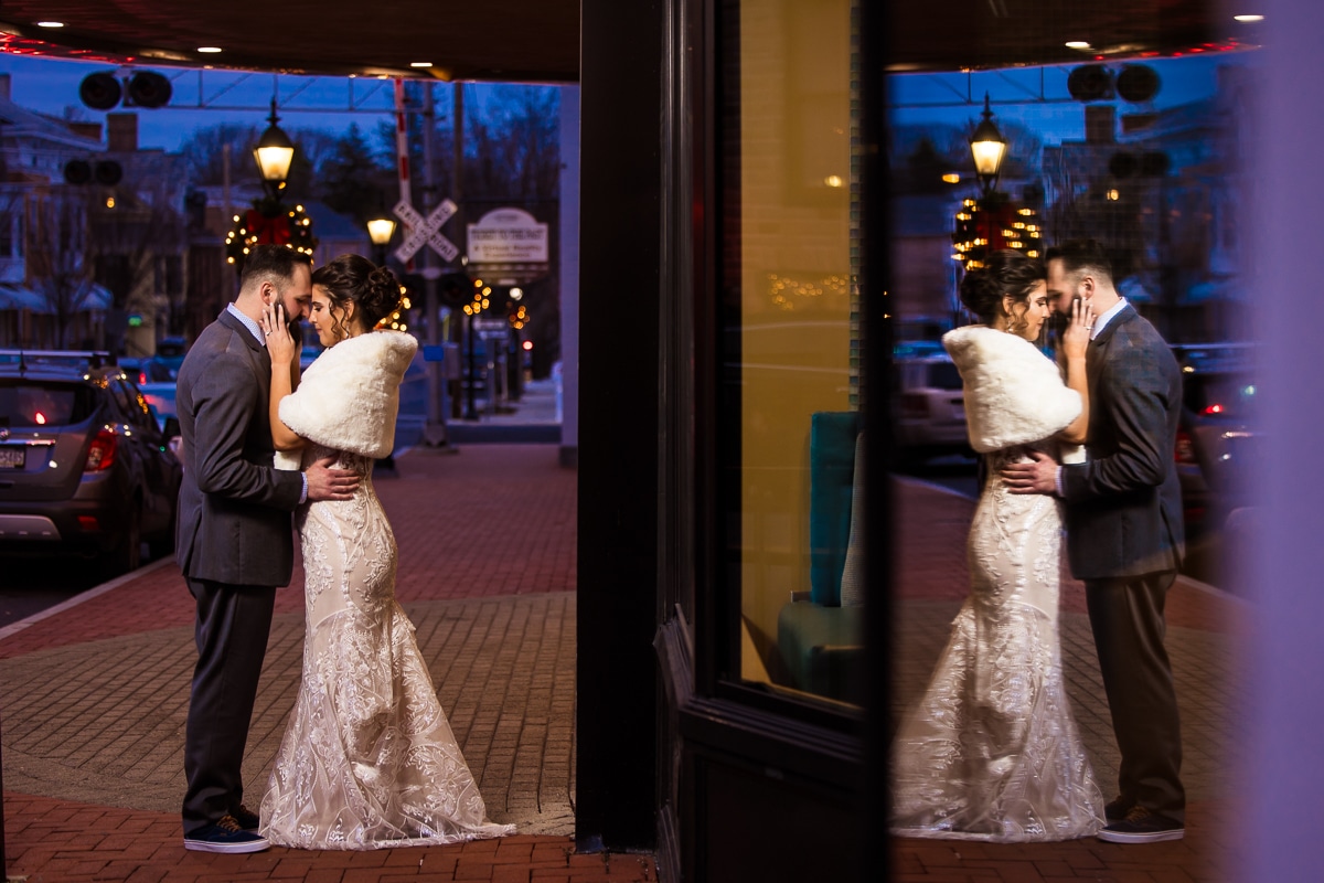 winter wedding photographer, lisa rhinehart, captures this reflective image of the bride and groom hugging underneath the theatre sign during their Gettysburg Hotel Wedding