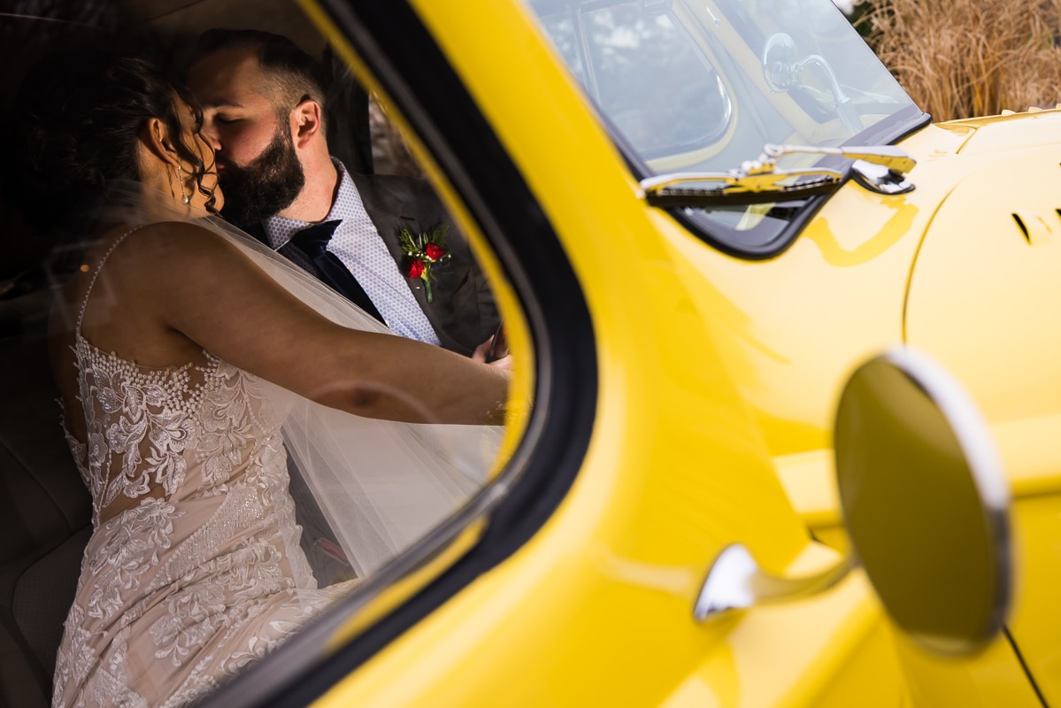 unique, creative image of the bride and groom kissing inside of the yellow packard convertible car during their Gettysburg Hotel Wedding pictures