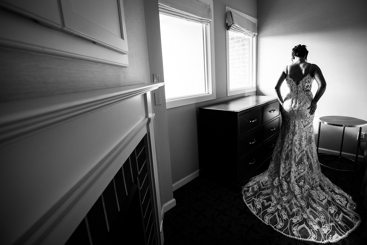 black and white image of the bride facing away from the camera in her wedding dress before her wedding ceremony at mount st. marys chapel