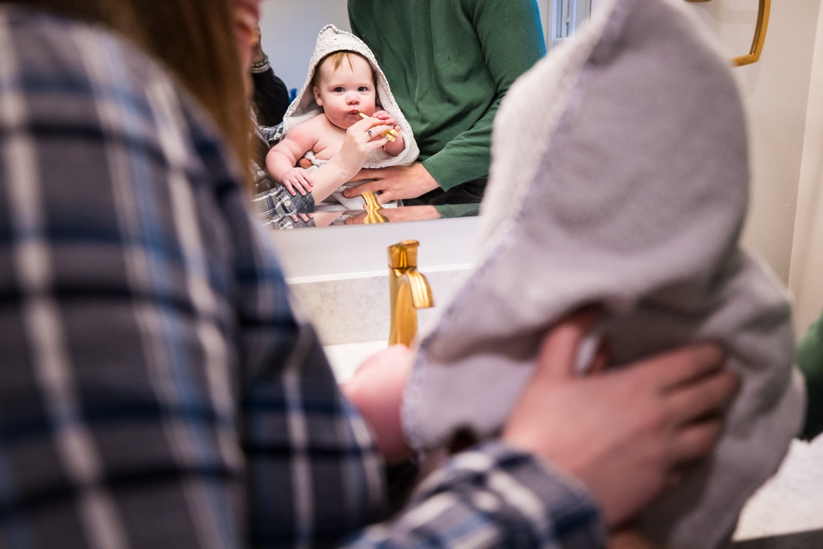 image of mom and dad helping to brush the babies teeth after bathtime before she heads to bed