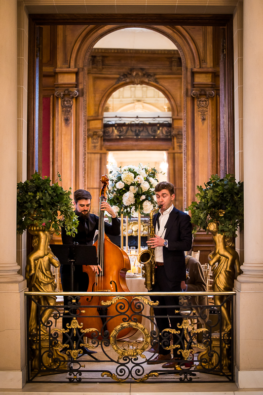 rhinehart photography captures the live music playing their instruments above the staircase inside of this Washington dc wedding venue 