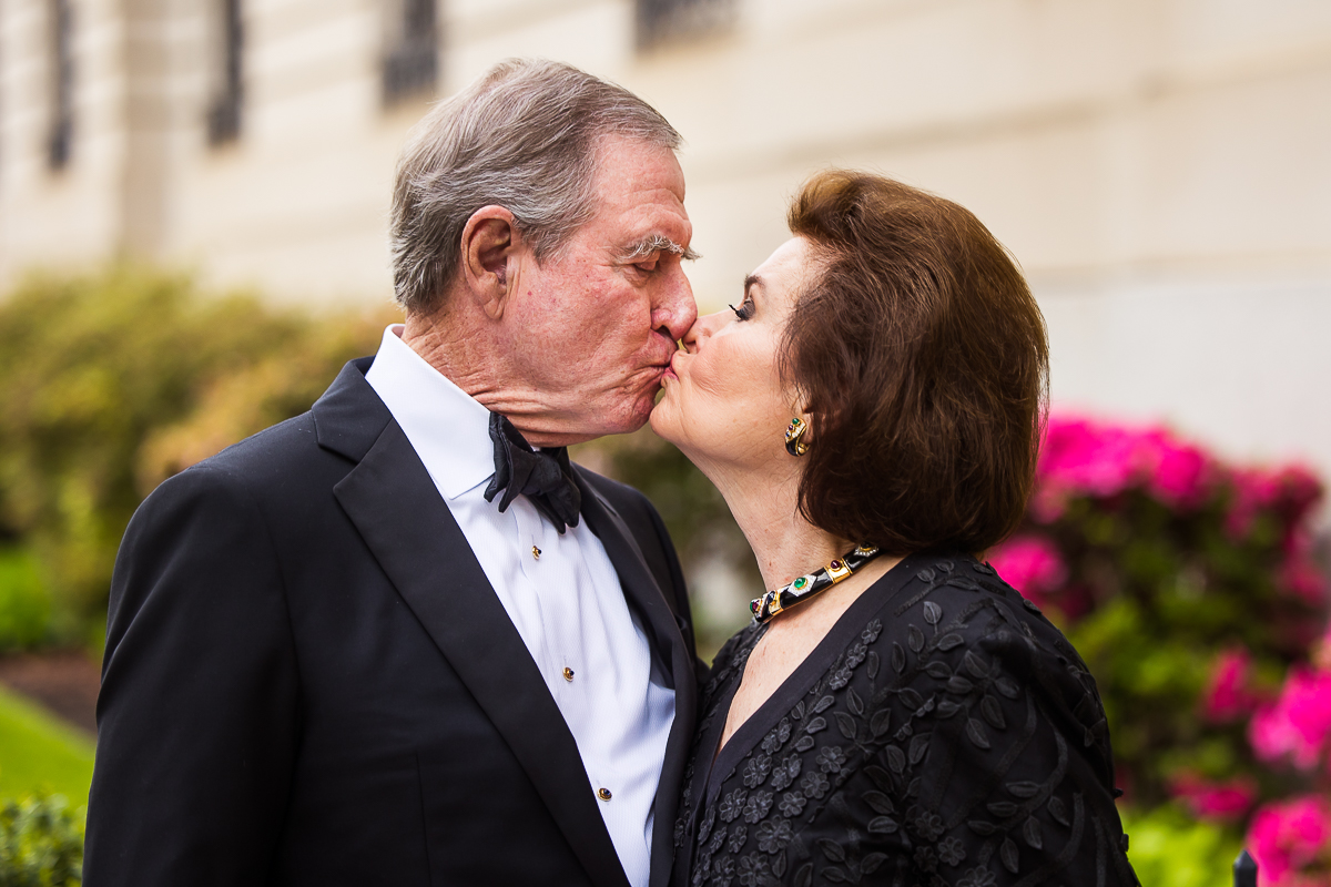 Perry Belmont House Wedding Photographer, rhinehart photography, captures this authentic, genuine image of the father and mother kissing other another outside of this Washington dc wedding venue