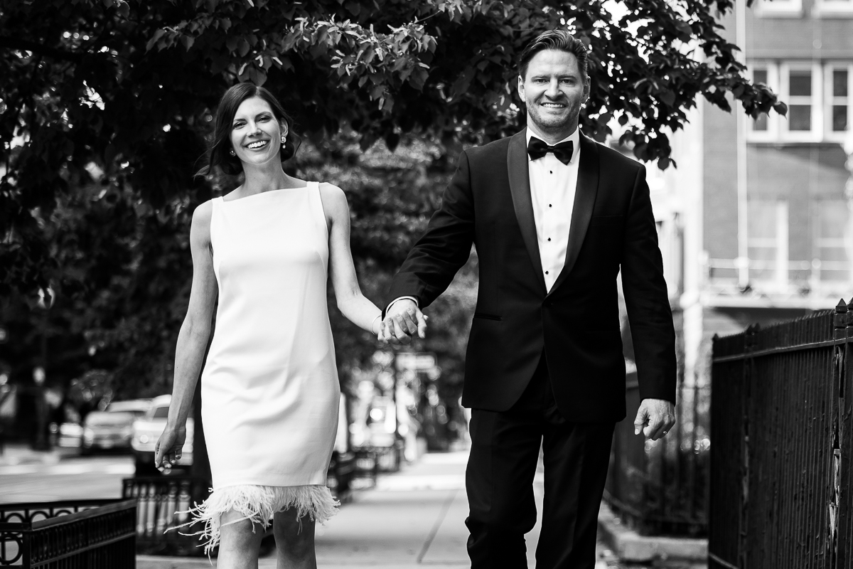 This traditional black and white image of the bride and groom captures this couples genuine love and happiness with one another as they walk down the streets holding each others hands smiling 