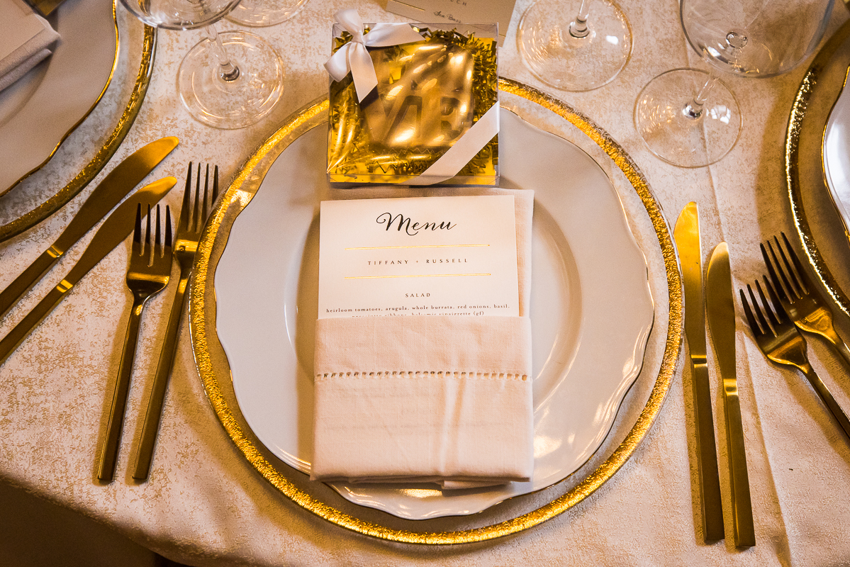 Detail photo of the place settings from this dc wedding with gold details in the plates, packaging and silverwear