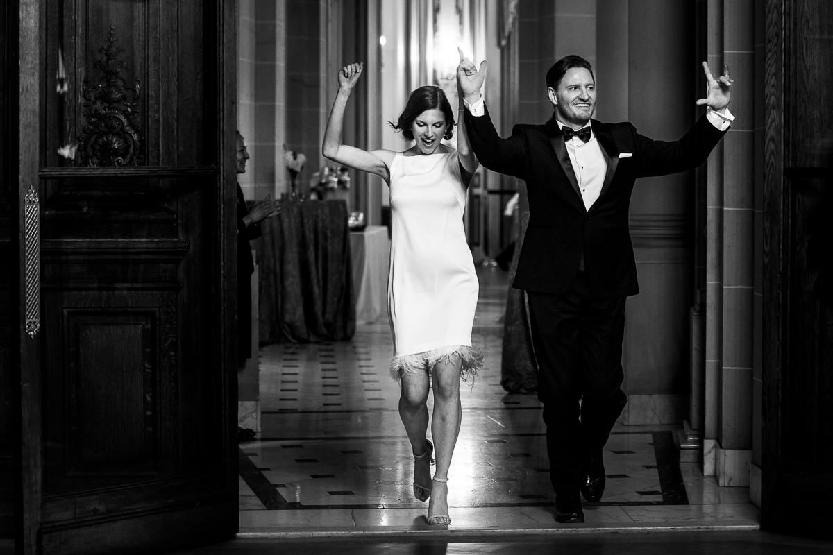 Perry Belmont House Wedding Photographer, rhinehart photography, captures this fun, authentic black and white image of the couple entering their wedding reception inside of this elegant Washington dc wedding venue 