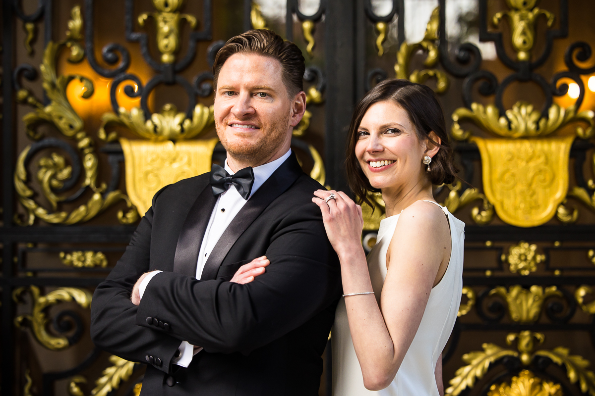 Perry Belmont House Wedding Photographer, lisa rhinehart, captures the couple posing with one another in front of this Washington dc wedding venue which has unique gold scroll doors