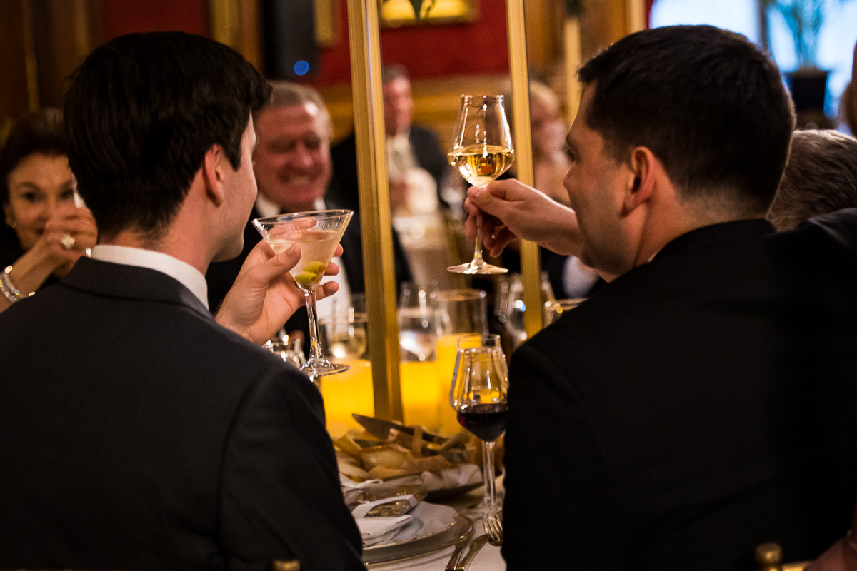 wedding photographer, lisa rhinehart, captures this image of guests lifting their glasses giving a toast during the speeches part of the reception 