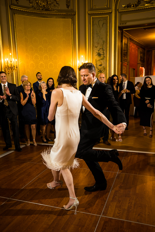 wedding photographer, rhinehart photography, captures the couple dancing together as their guests standing around clapping and watching inside of this dc wedding venue 