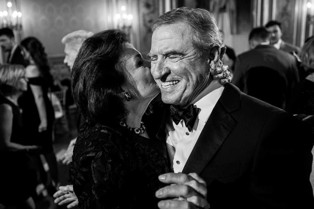 Perry Belmont House Wedding Photographer, lisa rhinehart, captures this timeless black and white image of the parents dancing with each other and kissing one another inside of this dc wedding venue 