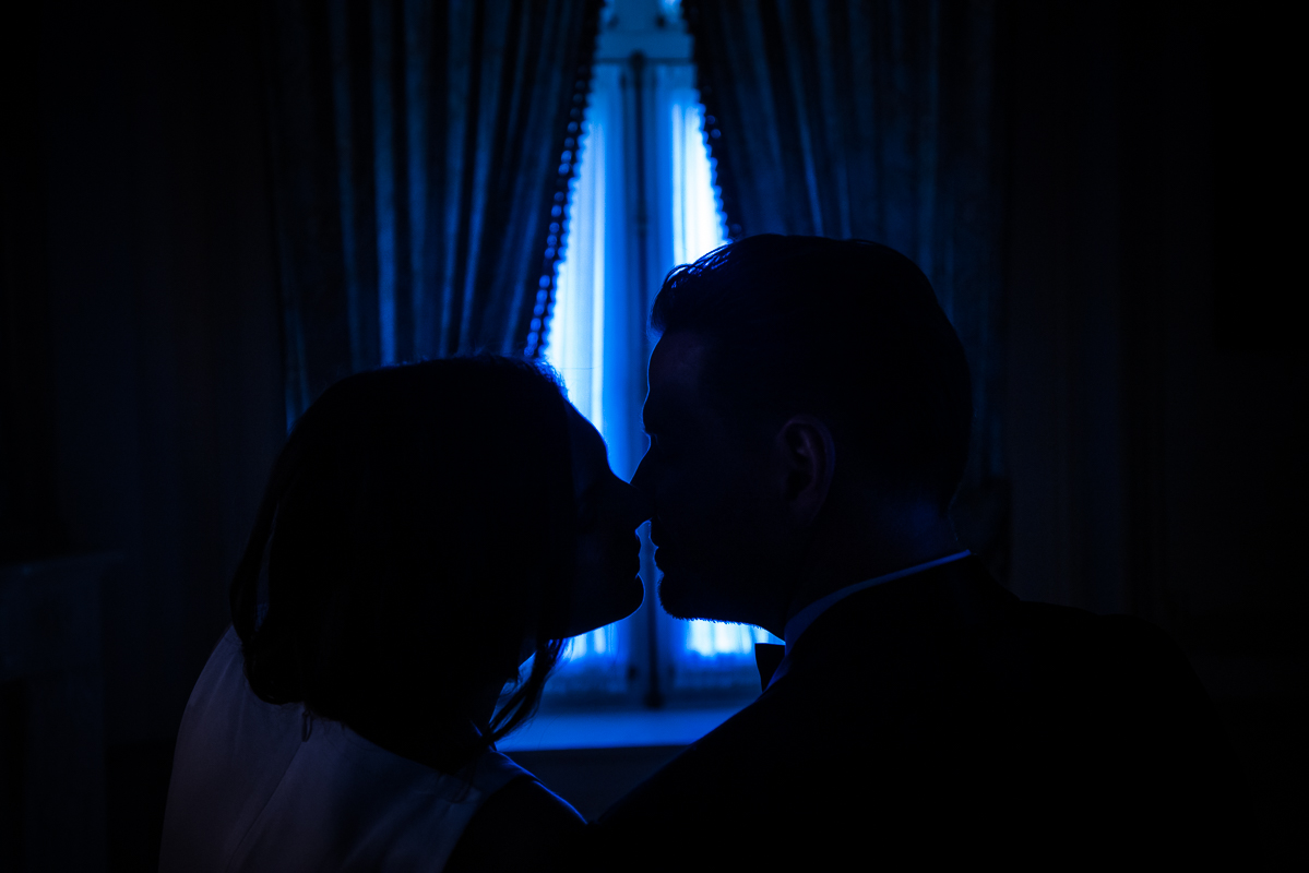 Perry Belmont House Wedding Photographer, lisa rhinehart, captures this blue lit silhouette of the couple kissing one another at the end of the night after their wedding reception in Washington dc 