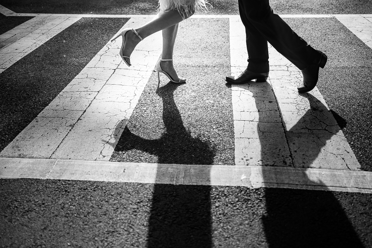 Classic, timeless, creative black and white image of the bride and grooms feet and their shadows as they walk across the crosswalk on the road from their Washington dc wedding venue 
