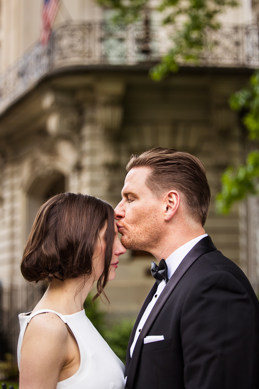 rhinehart photography captures this elegant image of the groom kissing his bride outside of their Washington dc wedding venue 