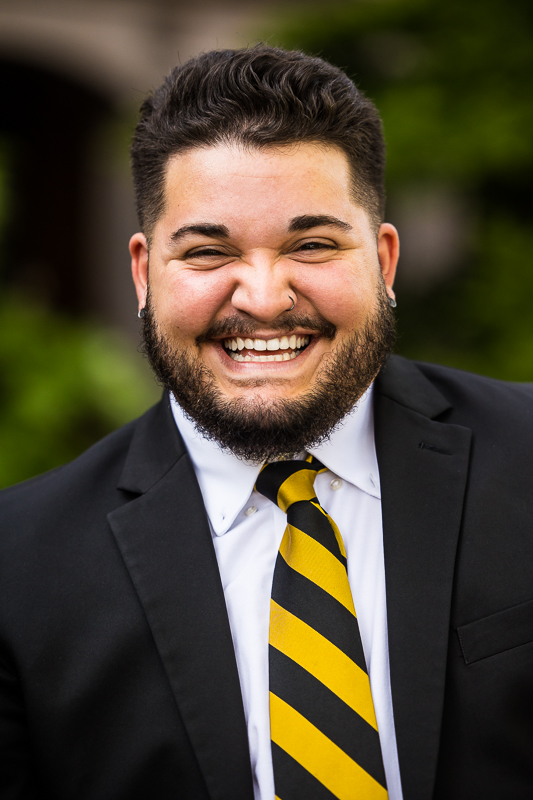 senior portait photographer, Lisa Rhinehart, captures this fun, authentic image of this graduating senior with a huge smile on his face as he is in his suit and tie for senior pictures 