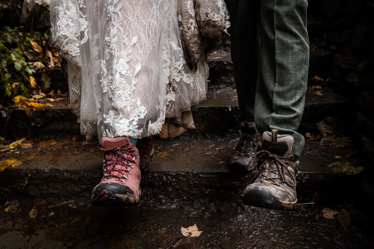 unique, authentic, creative image of the couple hiking together in their hiking boots and wedding attire as they explore watkins glen together for the first time during their after session