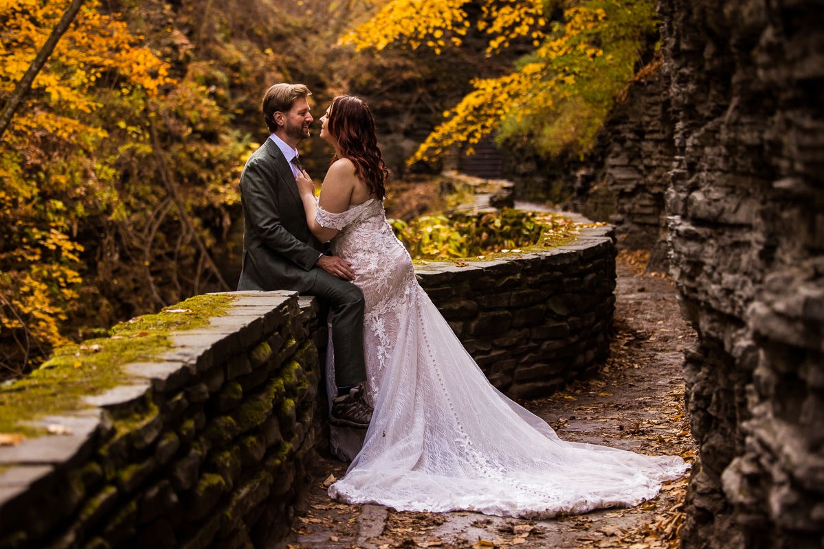 image of the couple hugging one another as they explore watkins glen state park together in their wedding attire during their unique, creative, fun, adventurous after session