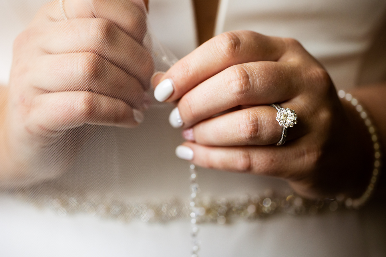 Best PA wedding photographer, lisa rhinehart, captures this close up image of the brides white nails, sparkling ring and her wedding veil before her wedding ceremony in Virginia 