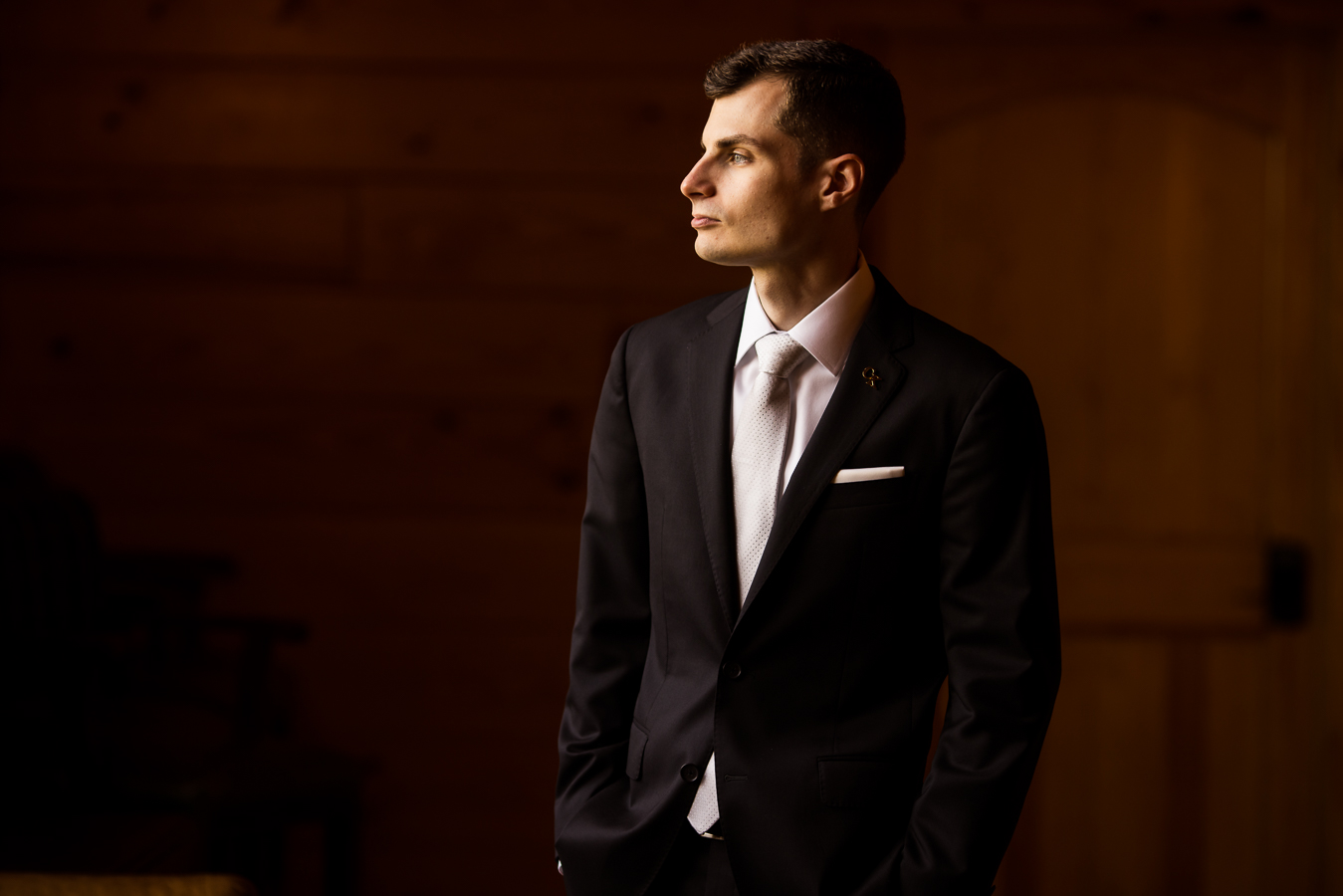 Middleburg Barn Wedding Photographer, captures this image of the groom as he stares off into the distance lit by dramatic lighting
