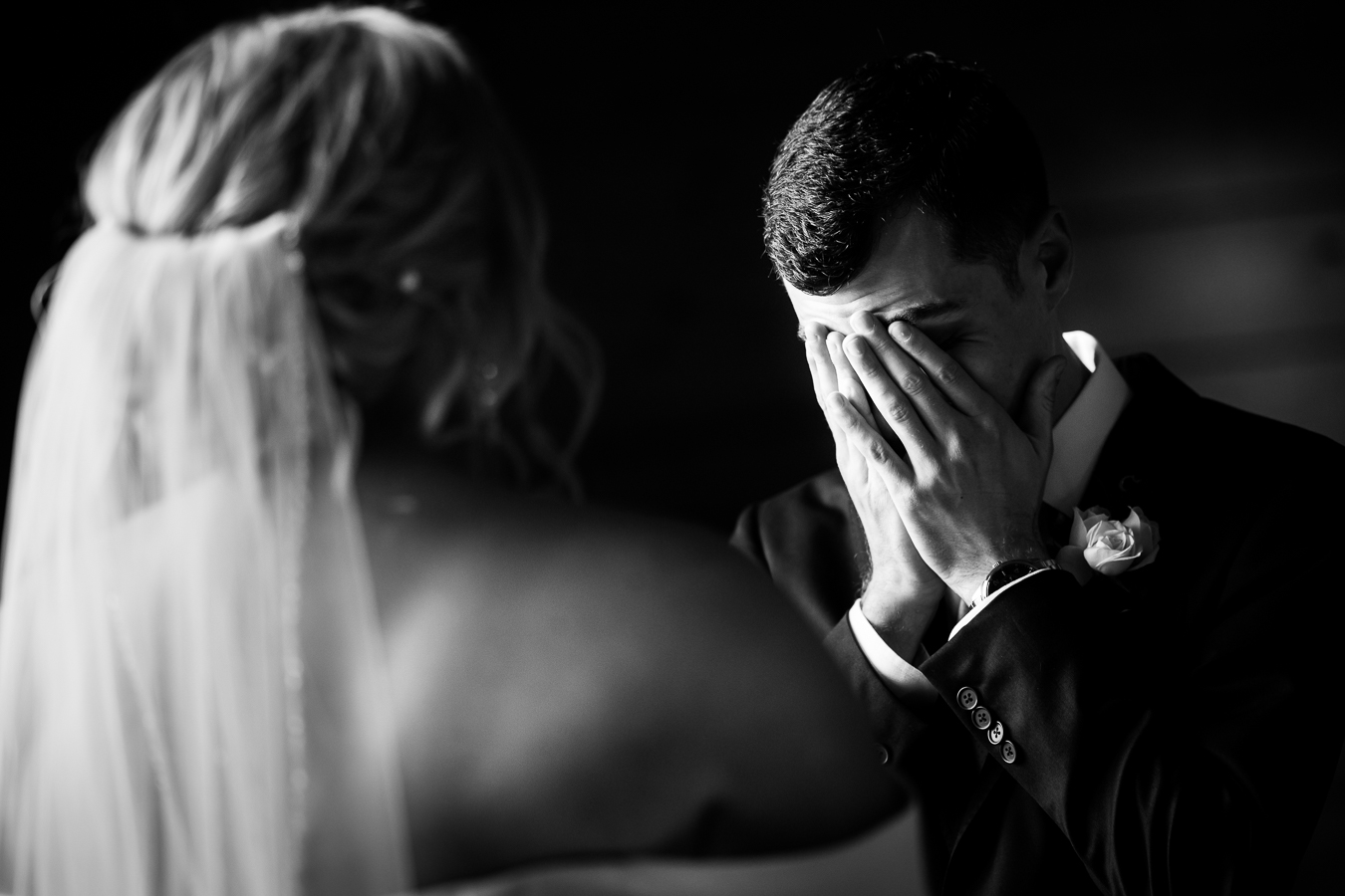 authentic wedding photographer, lisa rhinehart, captures this authentic black and white image of the groom holding his hands to his face as he cries from seeing his bride for the first time before their wedding ceremony in Virginia 