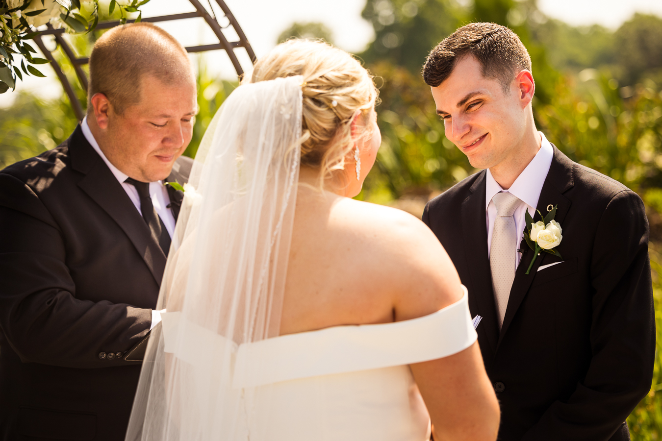 Creative wedding photographer, lisa rhinehart, captures this authentic image of the groom smiling at his bride during their wedding ceremony in Virginia 