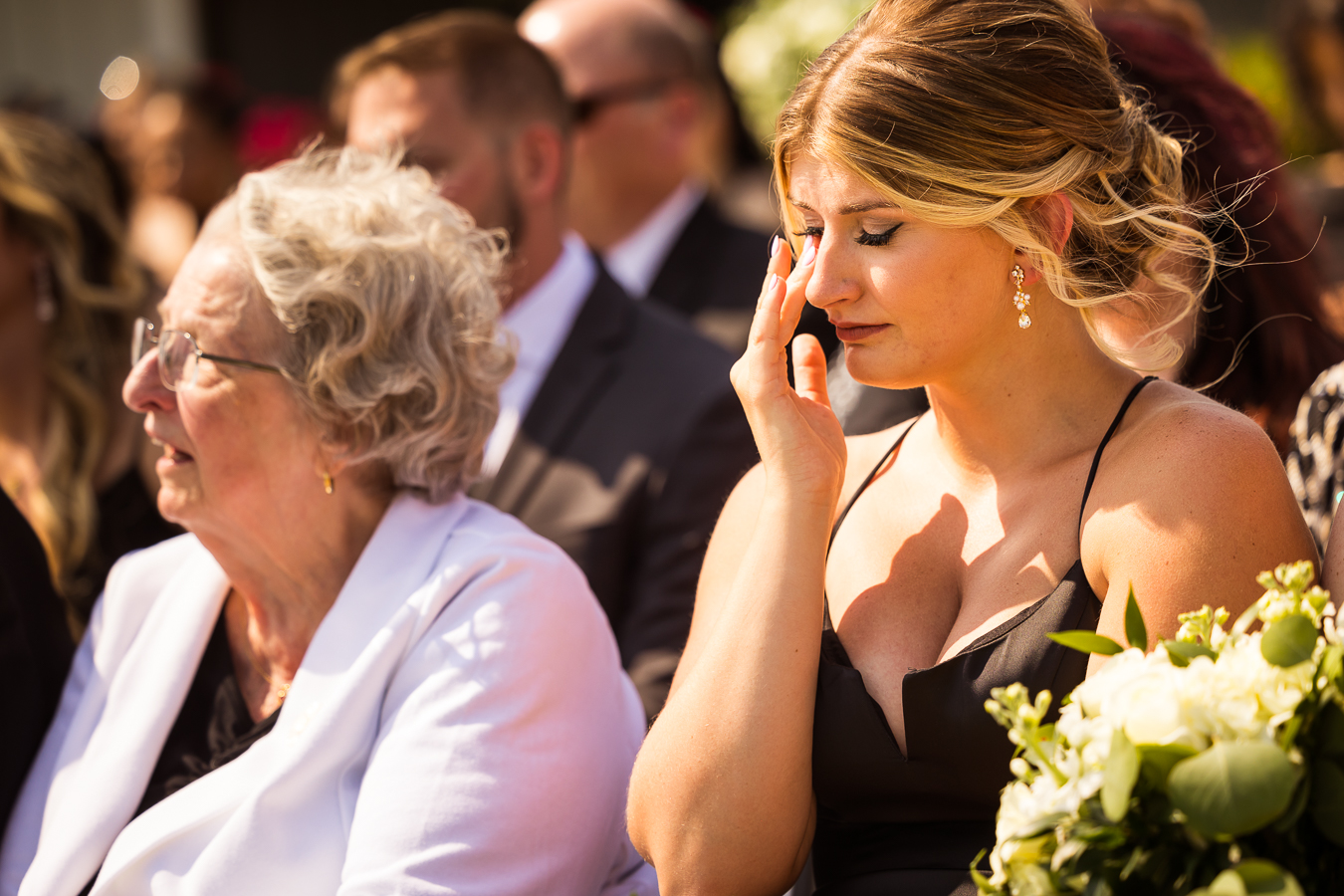 image of guests wiping away tears as they listen to the bride and groom share their vows during this middleburg barn wedding ceremony 